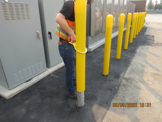 Construction Worker using a Hartman Bollard Lifter to lift a 4" removable pipe bollard with ease, using only one hand
